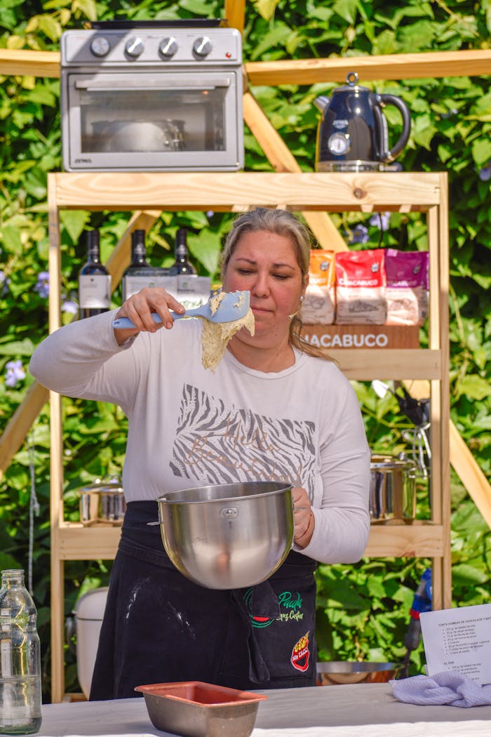 Chef preparing dough at an outdoor baking class, blending culinary skills and nature.