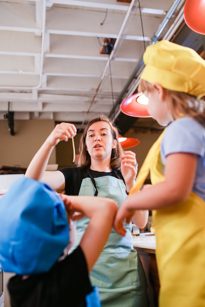 A lively cooking class with children and an instructor in a kitchen setting, perfect for learning and fun.
