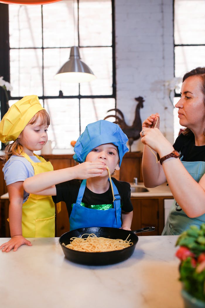 A mother and her children joyfully cooking together, preparing pasta in the kitchen.